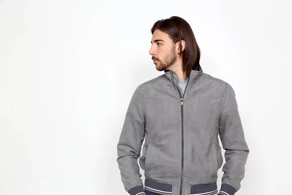 Uzun saçlı ve sakallı çekici erkek model izole bir arka planda stüdyoda poz veriyor. Tarz, trendler, moda konsepti.