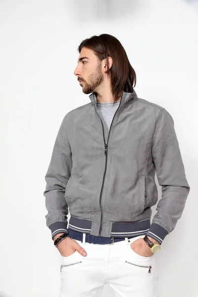 Uzun saçlı ve sakallı çekici erkek model izole bir arka planda stüdyoda poz veriyor. Tarz, trendler, moda konsepti.