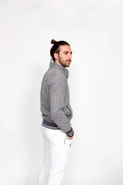 Uzun saçlı ve sakallı çekici erkek model izole bir arka planda stüdyoda poz veriyor. Tarz, trendler, moda konsepti.