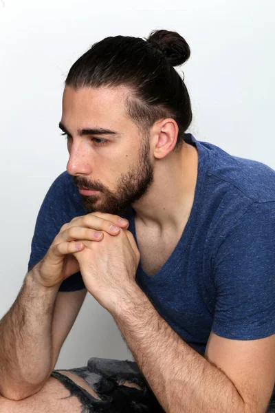 Uzun saçlı ve sakallı çekici erkek model izole bir arka planda stüdyoda poz veriyor. Tarz, trendler, moda konsepti.