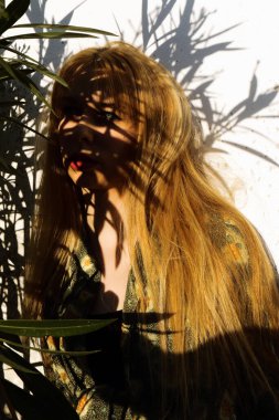 Mavi gözlü güzel sarışın kız poz veriyor. Sert ışık fotoğrafçılığı.