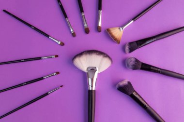 Mor arkaplanda makyaj fırçaları