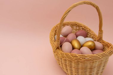 Pembe arka planda sepetteki paskalya yumurtaları. Metnin için yeri olan kartpostal