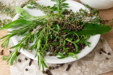 Beyaz bir porselen tabakta Herbes de Provence ve baharatlar.