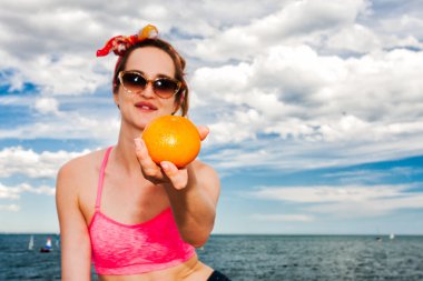 Çekici kadın bir plajda güneş gözlüğü vermek turuncu