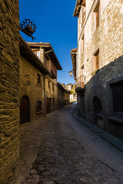 RUPIT, CATALONIA, SPAIN, April 2016: A view of the medieval town of Rupit- street with brutal rustic medieval houses