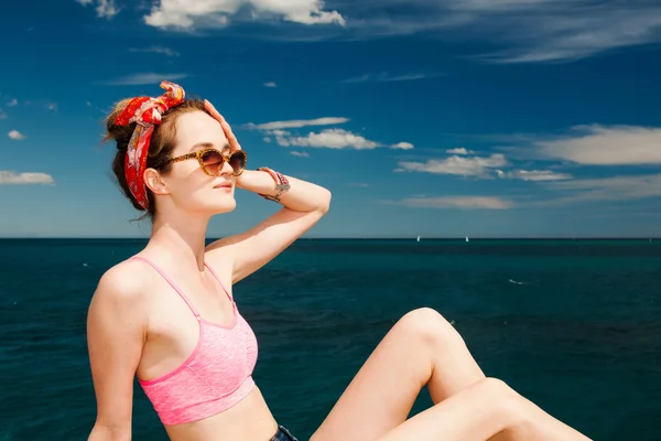 Modelo menina atraente em óculos de sol banhos de sol na praia — Fotografia de Stock