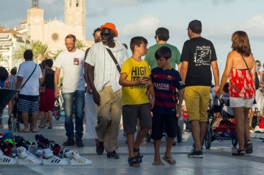Sitges, İspanya - 21 Ağustos 2016: Afrikalılar mesire Sitges turistlere taklit ürünler satmak.