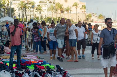 Sitges, İspanya - 21 Ağustos 2016: Afrikalılar mesire Sitges turistlere taklit ürünler satmak.