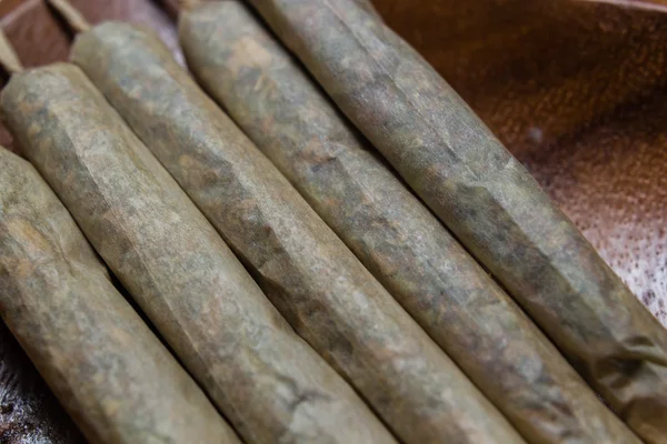 Voorraad van hand gemaakt marihuana gewrichten op houten schotel — Stockfoto