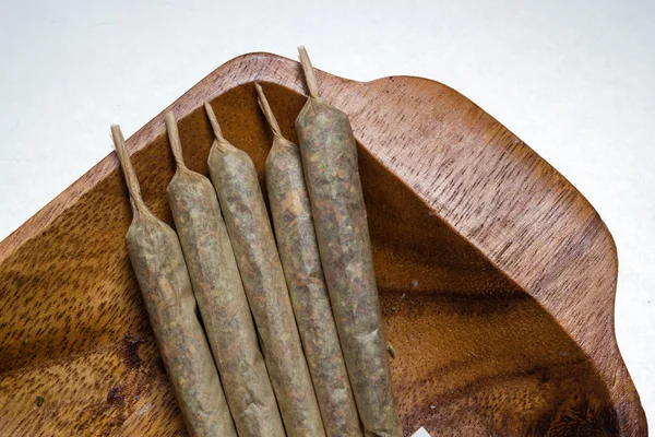 Stock of hand made marijuana joints on wooden platter — Stock Photo, Image