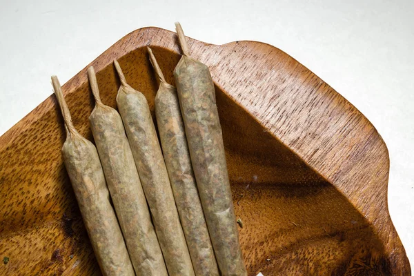 Stock of hand made marijuana joints on wooden platter — Stock Photo, Image