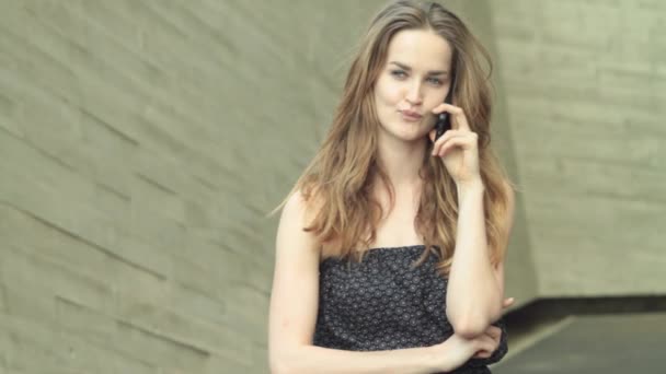 Красивая девушка модель серьезно разговаривает по мобильному телефону — стоковое видео