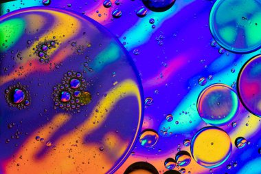 Görüntü soyut bir tema, yağ damlaları ile karıştırılmış cam bir kap içinde su bir tablet üzerinde halüsinojen çizimler.