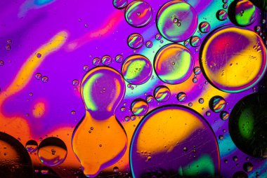 Görüntü soyut bir tema, yağ damlaları ile karıştırılmış cam bir kap içinde su bir tablet üzerinde halüsinojen çizimler.