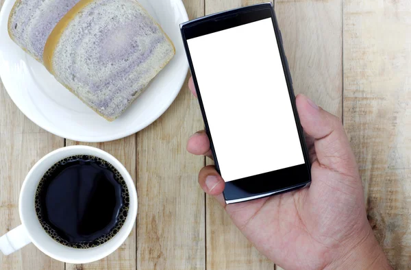 Woo chleb na białe płytki, smartphone w ręku na filiżankę kawy, — Zdjęcie stockowe