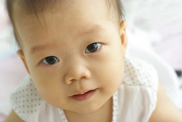 可爱的亚洲婴儿看向某人的脸. 免版税图库图片