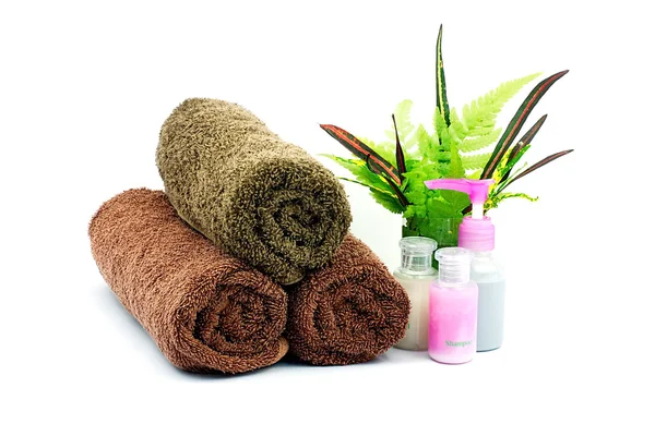 Shampoo and Shower gel bottles and brown towel and green leaves — Stock Photo, Image