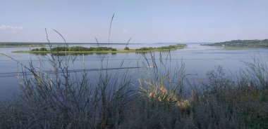 Adaları ve yelkenli teknesi olan güzel bir nehir manzarası, yaz, akşam