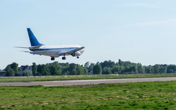 Passenger airplane landing at airport — Stock Photo, Image