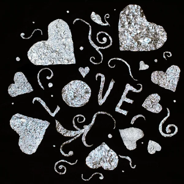 Hearts of foil on a black background. Valentine's Day. — Stock Photo, Image