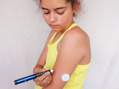 Girl stands and injects insulin from insulin pen in arm. On the arm is also placed white sensor for continuous glucose monitoring in blood - CGM. Diabetes type 1. Insulin dependent clipart