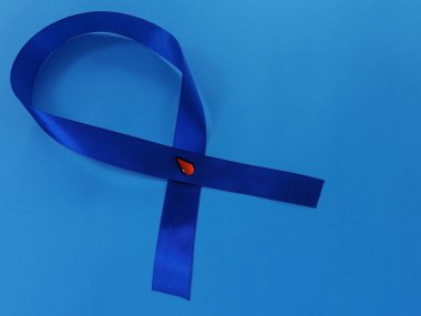 Diyabet sembolleri. Mavi arkaplanda kırmızı kan damlası olan mavi kurdele. Dünya Diyabet Günü, 14 Kasım. Metnin için sağ tarafa boşluk kopyala. Üst görünüm