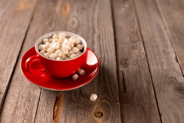 Ahşap masada kırmızı bardakta kremalı sıcak çikolata. Noel 'ler kış sıcak içecek menüsü tarifi