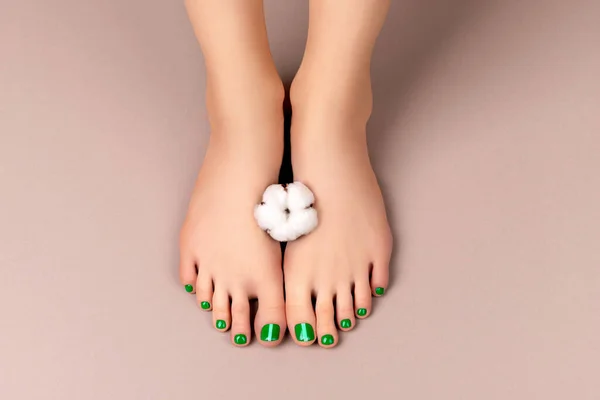 Hermosas piernas de las mujeres con sping diseño de uñas de verano sobre fondo de color neutro — Foto de Stock