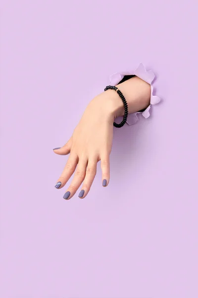 Mão Das Mulheres Com Manicure Matte Roxo Através Buraco Fundo — Fotografia de Stock