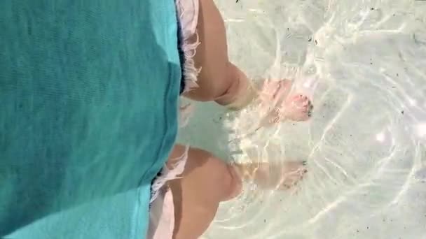 Kvinnors ben med trendig grön spik design promenader på stranden — Stockvideo