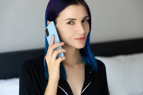 Las mujeres con el pelo azul en el dormitorio habla por teléfono móvil —  Fotos de Stock