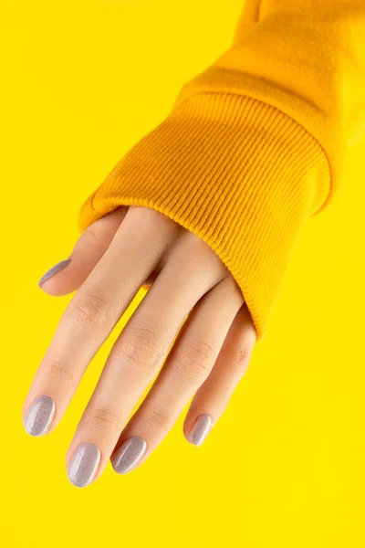 Красивые ухоженные женщины рука с модным дизайном ногтей на желтом фоне — стоковое фото