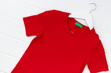 Düz görünüm kadınların tişörtleri beyaz arkaplanda askıda yatıyordu