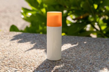 Sahilde deniz kenarında bir şişe güneş kremi. Cilt bakımı kavramı