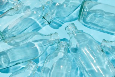 Mavi arka planda boş sınıf şişesi. Sıfır atık