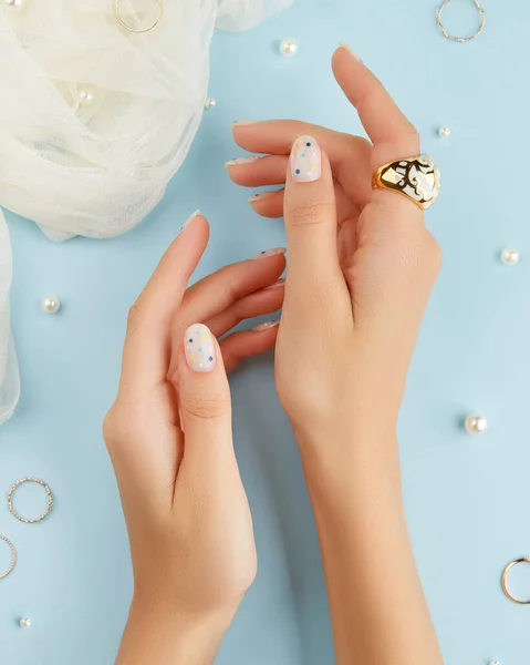 Hermosas manos de mujer arreglada con diseño de uñas de verano sobre fondo azul —  Fotos de Stock