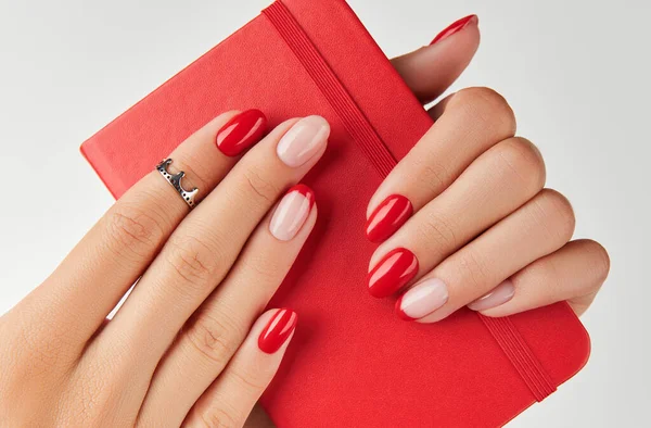 Womans hand holding notepad over white background. Manicure design trends — Stock Photo, Image