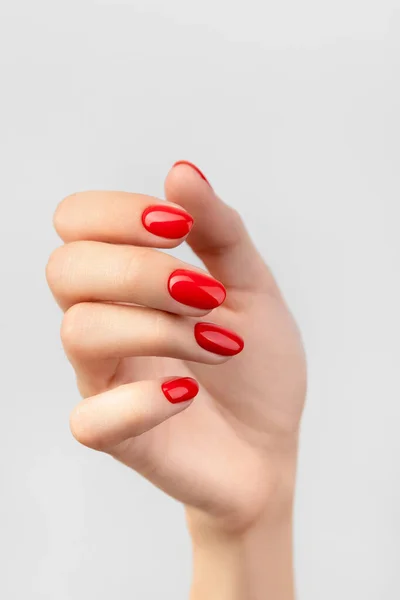 Bella mano delle donne con manicure rossa su sfondo grigio — Foto Stock