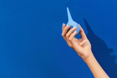 Mavi arka planda lavman tutan bakımlı kadınlar.