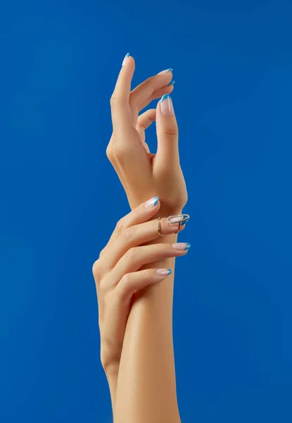 Όμορφες γυναίκες χέρια μοντέρνα σχεδίαση των νυχιών σε μπλε φόντο — Φωτογραφία Αρχείου