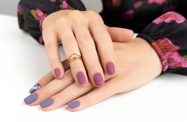 Beautiful womans hands with purple burgundy matte manicure — Stock Photo, Image