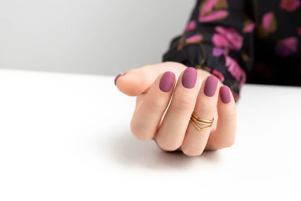 Beautiful womans hands with purple burgundy matte manicure — Stock Photo, Image