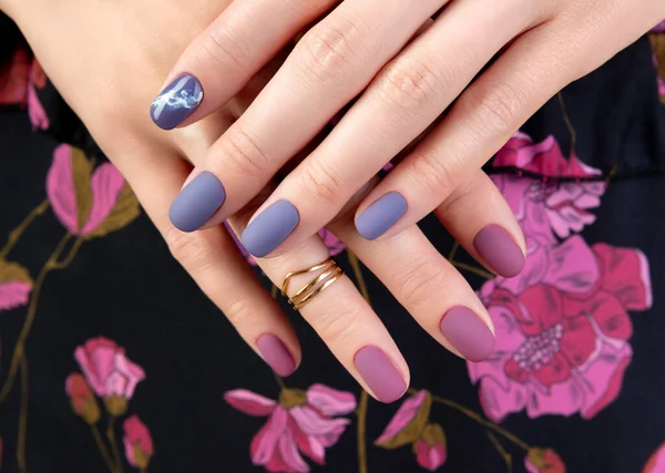 Hermosa mano de mujer con manicura mate púrpura en tela — Foto de Stock