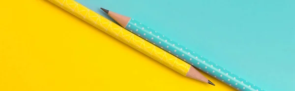 Vista superior de lápices de color turquesa y amarillo sobre fondo de papel creativo colorido — Foto de Stock