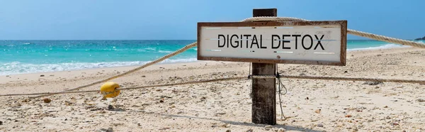 Tropikal plajda yazılı dijital detoksu olan eski tahta tabela.