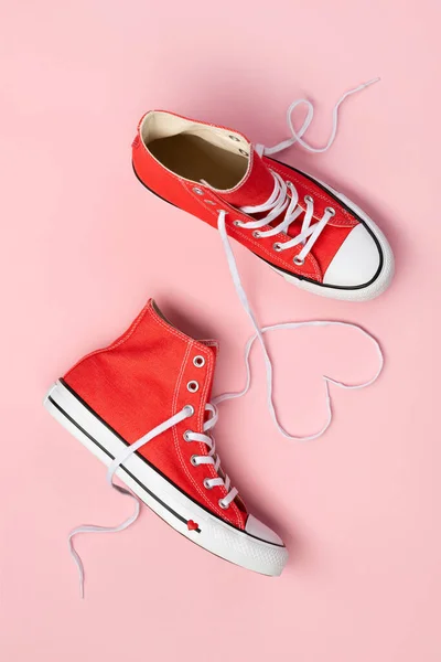 Ελάχιστη σύνθεση με κόκκινα sneakers σε ροζ φόντο — Φωτογραφία Αρχείου