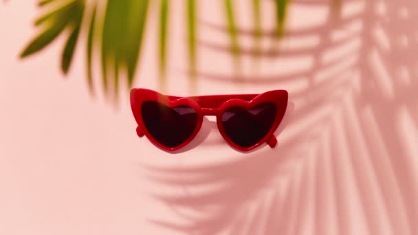 Stop motion animation with red heart shaped sunglasses on pink background — Stock Video