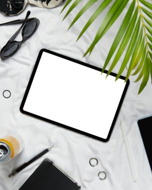 Düz ekran boş ekran dijital tablet giysiler ve aksesuarlar beyaz yatakta yatıyordu. Merkez ofis çalışma alanı.
