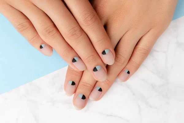 Schöne gepflegte Frauenhände mit nacktem und blau-mattem Nageldesign — Stockfoto